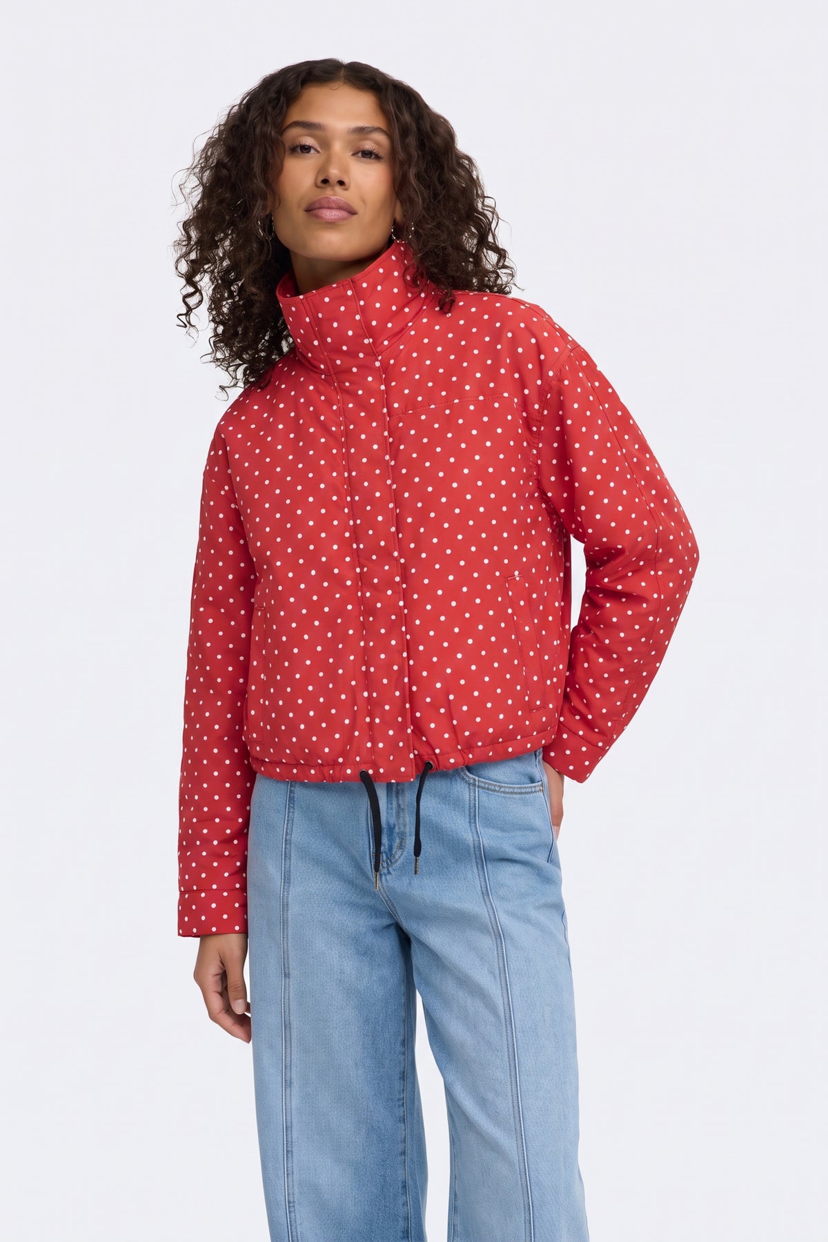 Red polka dot puffer jacket with blue jeans, on model
