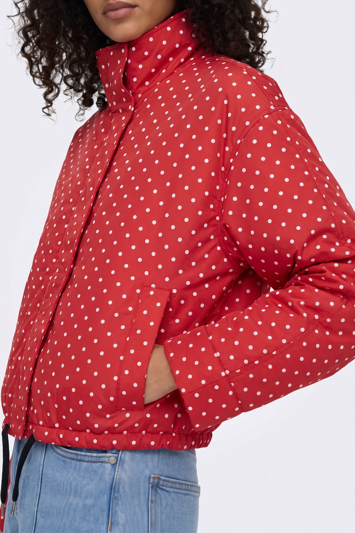 Red polka dot puffer jacket funnel collar and pocket detail, on model