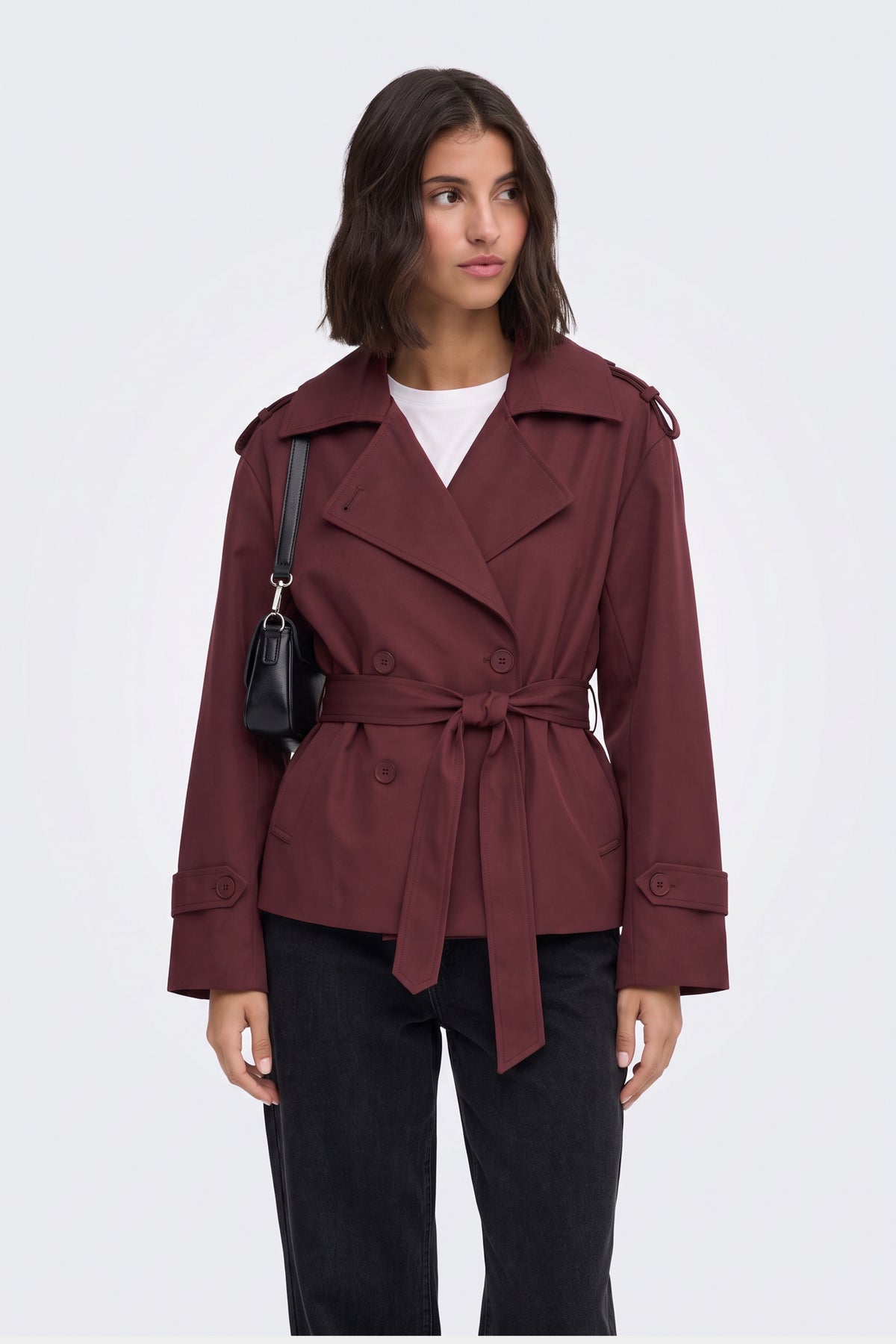 Burgundy short belted trench jacket on model, front view