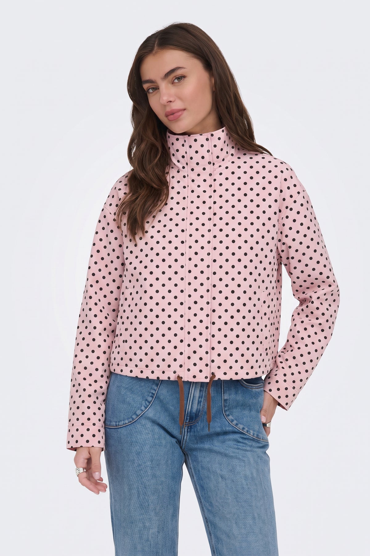 Pink polka dot jacket with blue jeans, on model