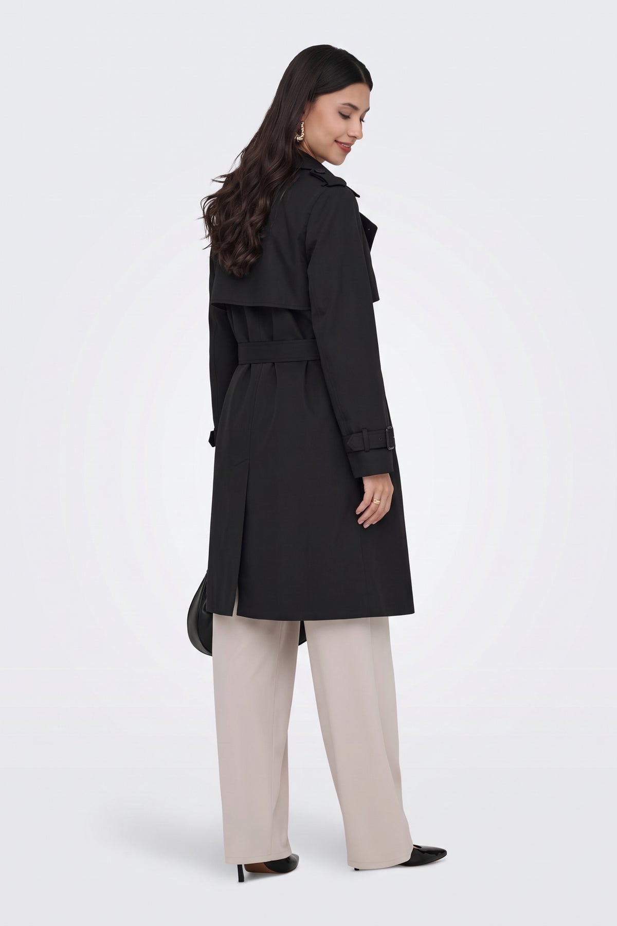 Black long trench coat side view on model