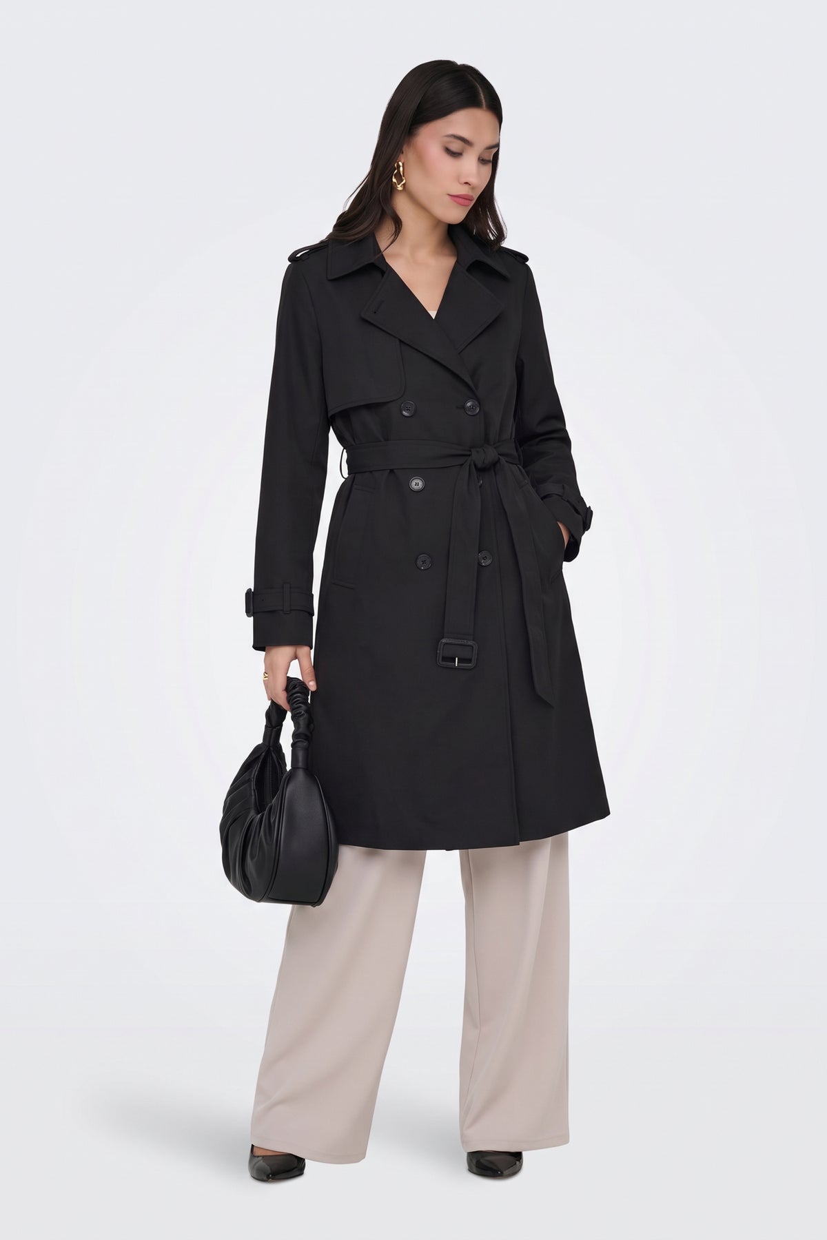 Black belted trench coat on model, front view