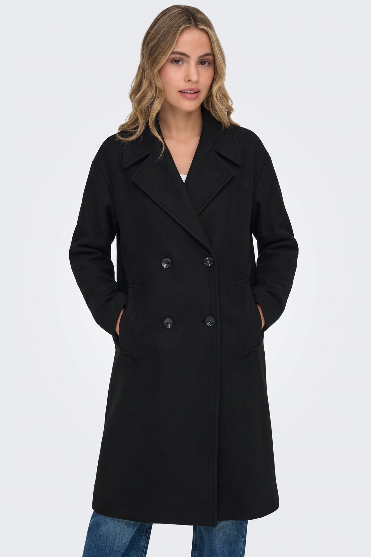 Black coat with wide notched lapels and welt pockets, close-up on model