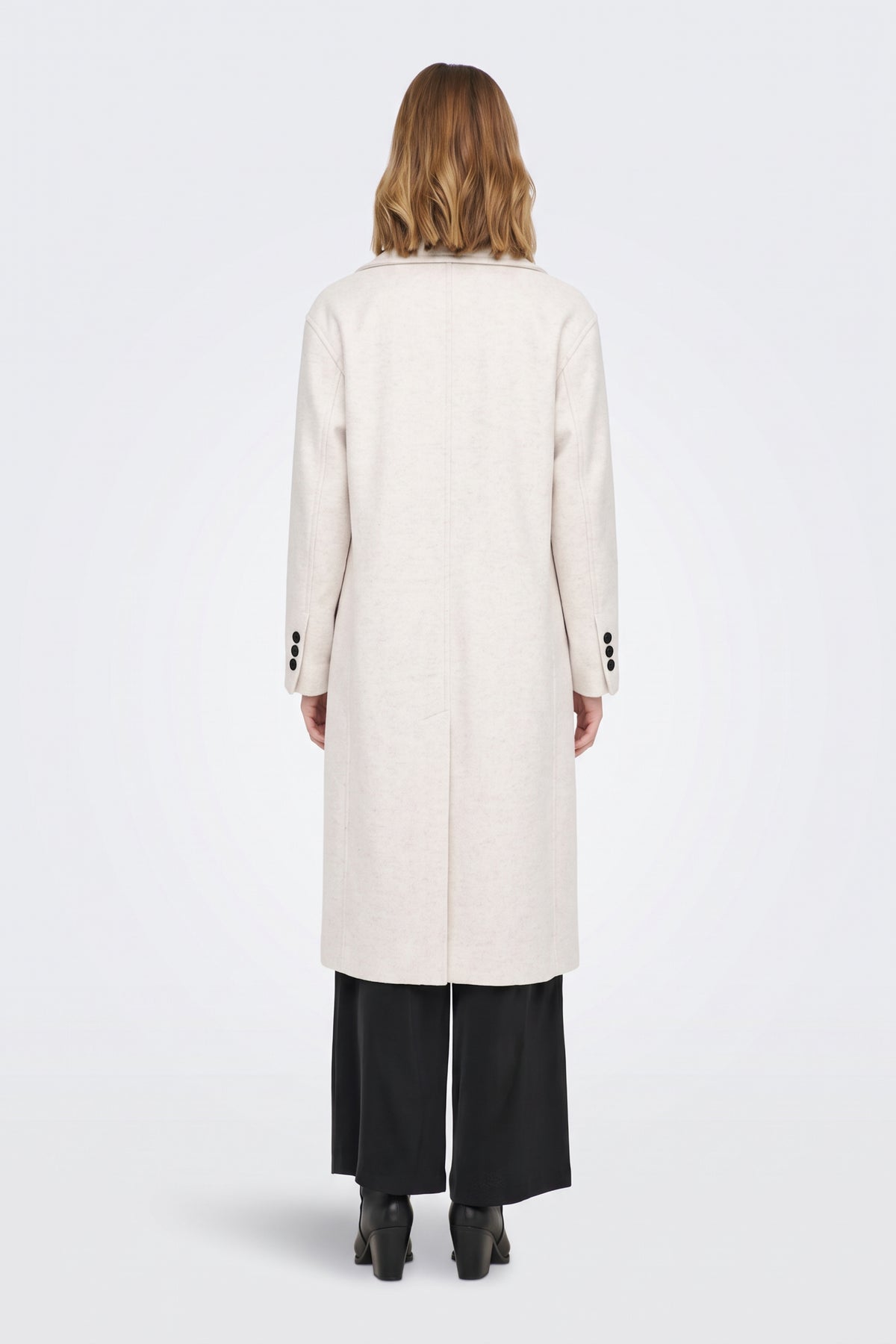 Long cream coat back view with cuff buttons and back vent, on model
