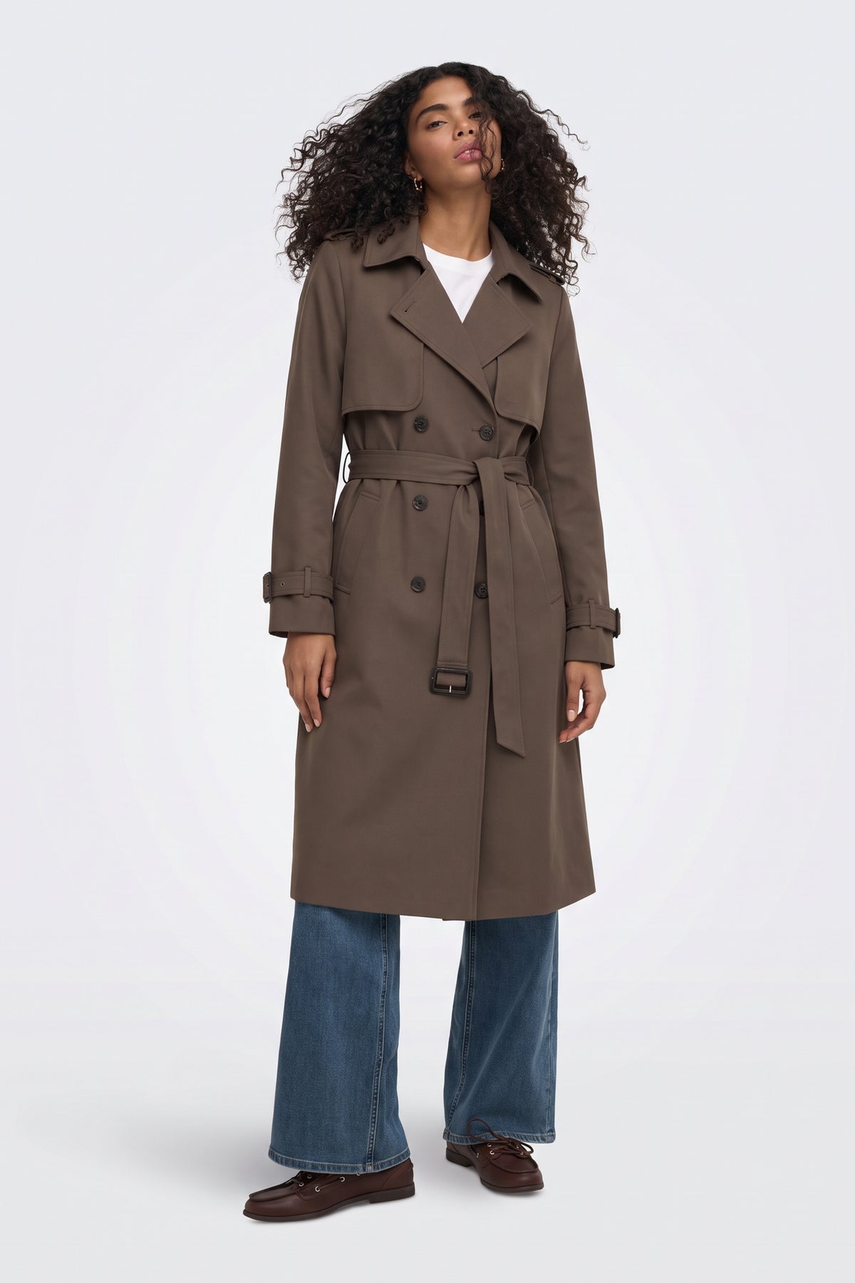 Brown belted trench coat on model, front view