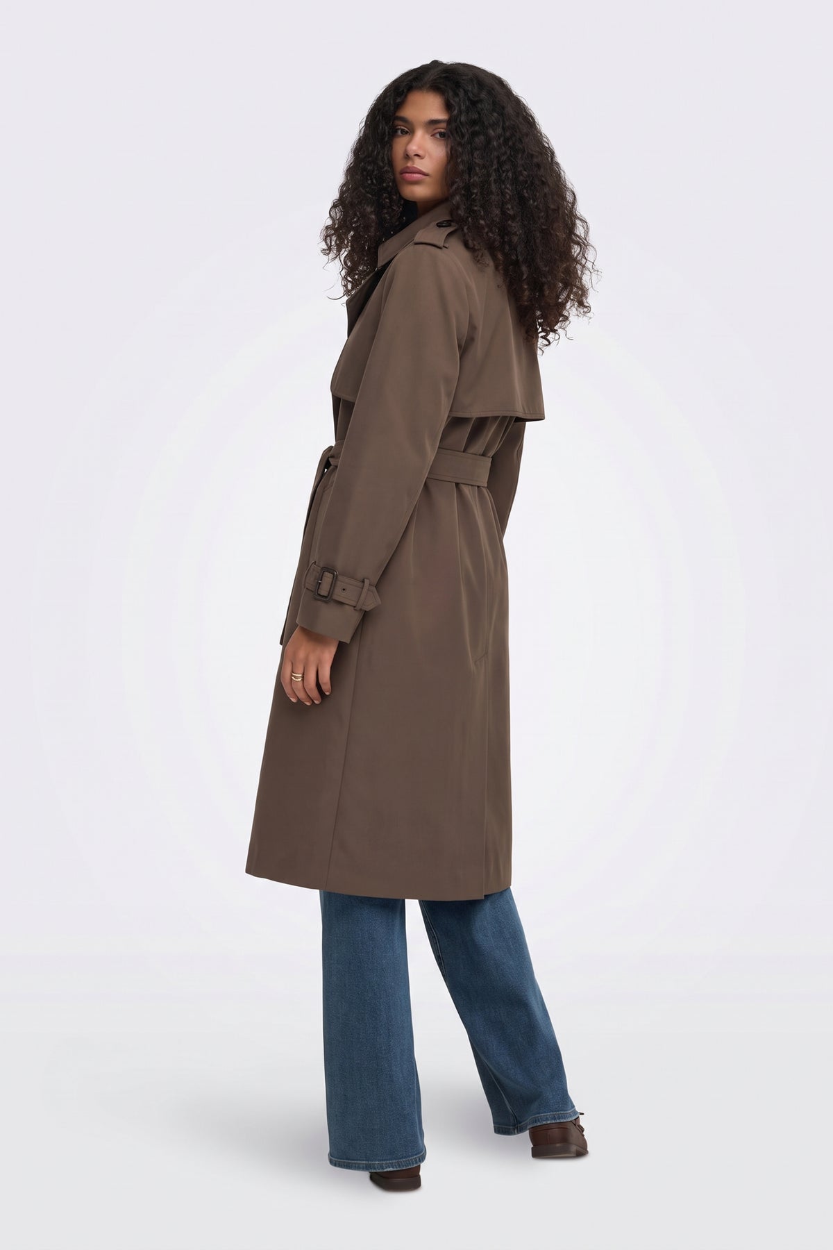 Brown long trench coat side view on model