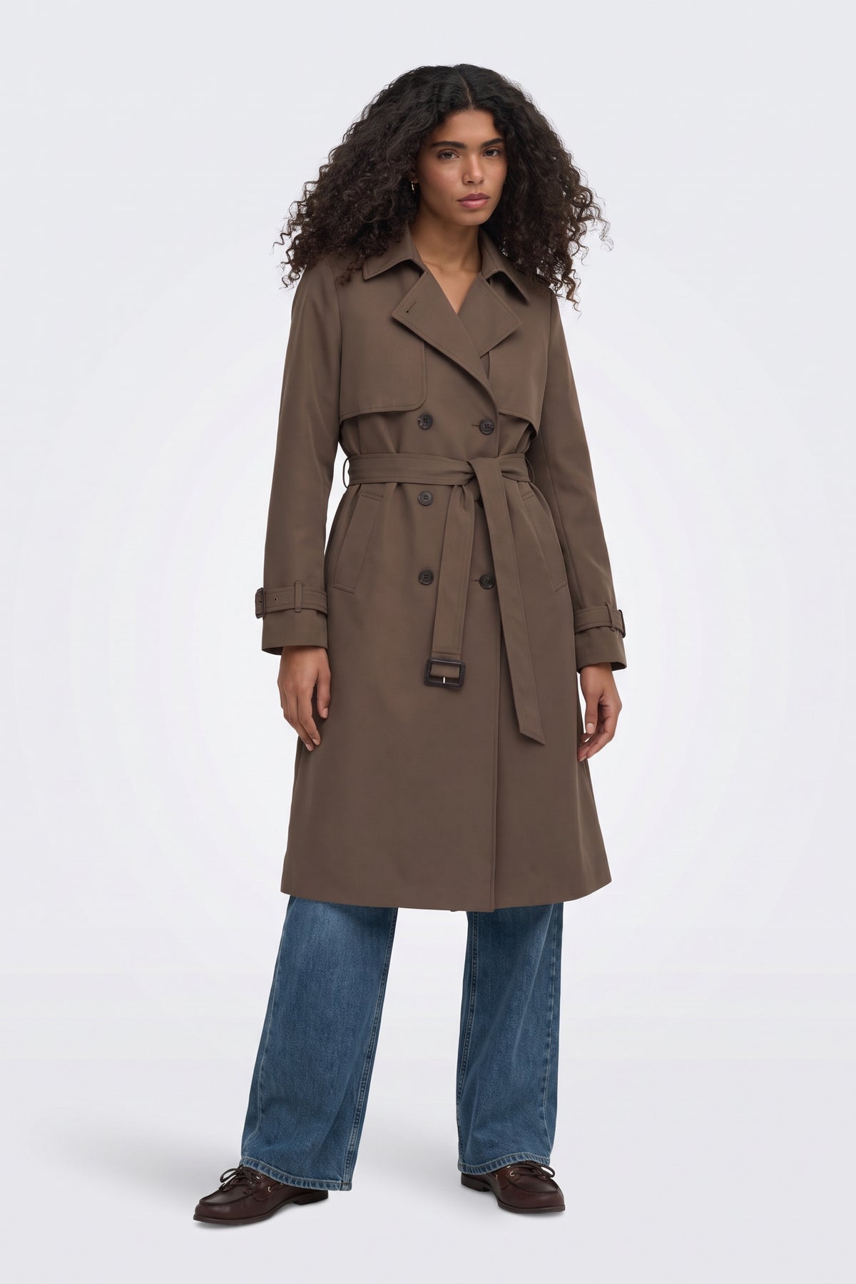 Brown long trench coat worn belted at the waist