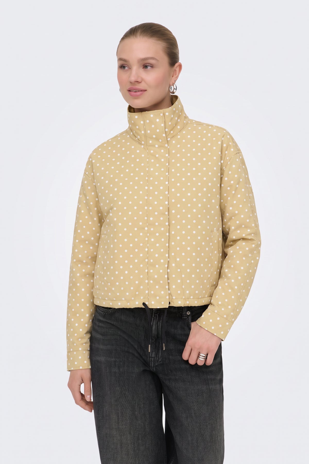 Yellow polka dot puffer jacket with black jeans, on model