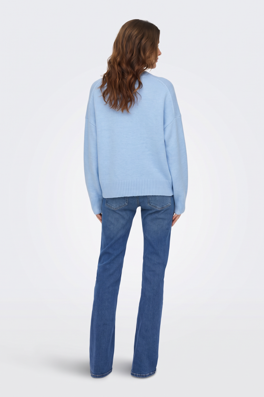 Light blue V neck jumper with blue jeans, back view on model