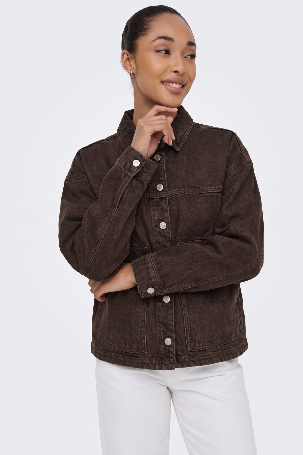 Brown washed denim jacket with collar up, on model
