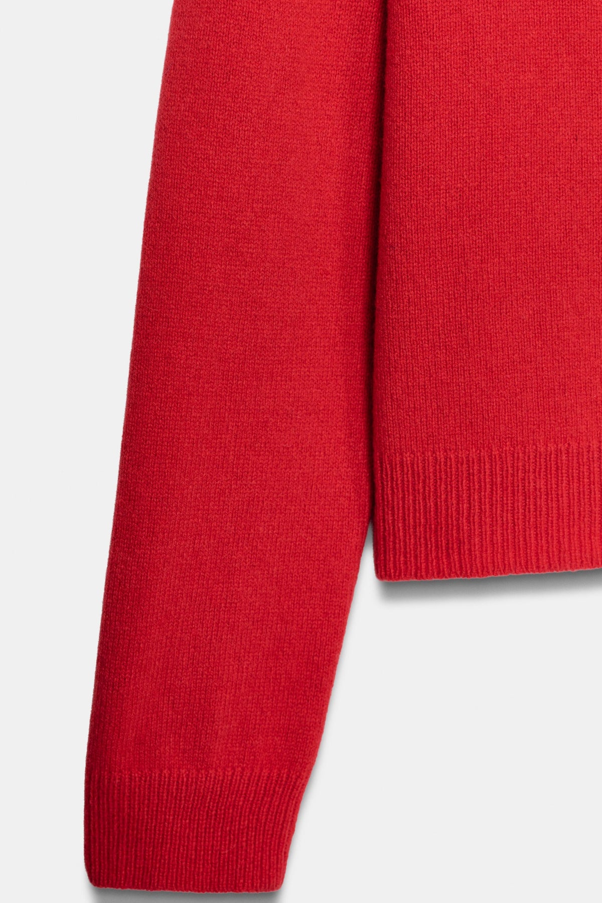 Red knit fabric and sleeve detail close up