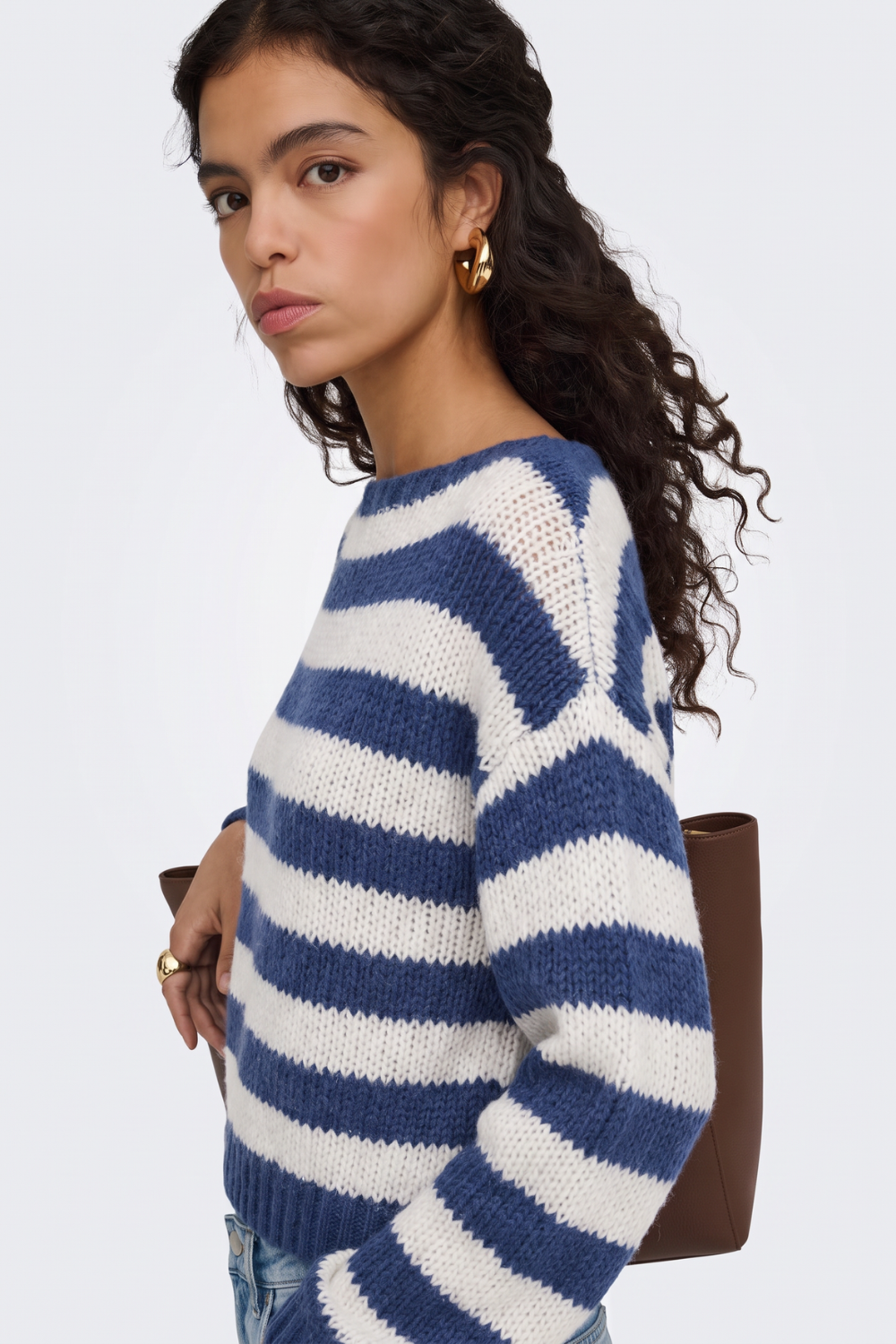 Blue striped chunky knit jumper, side view on model