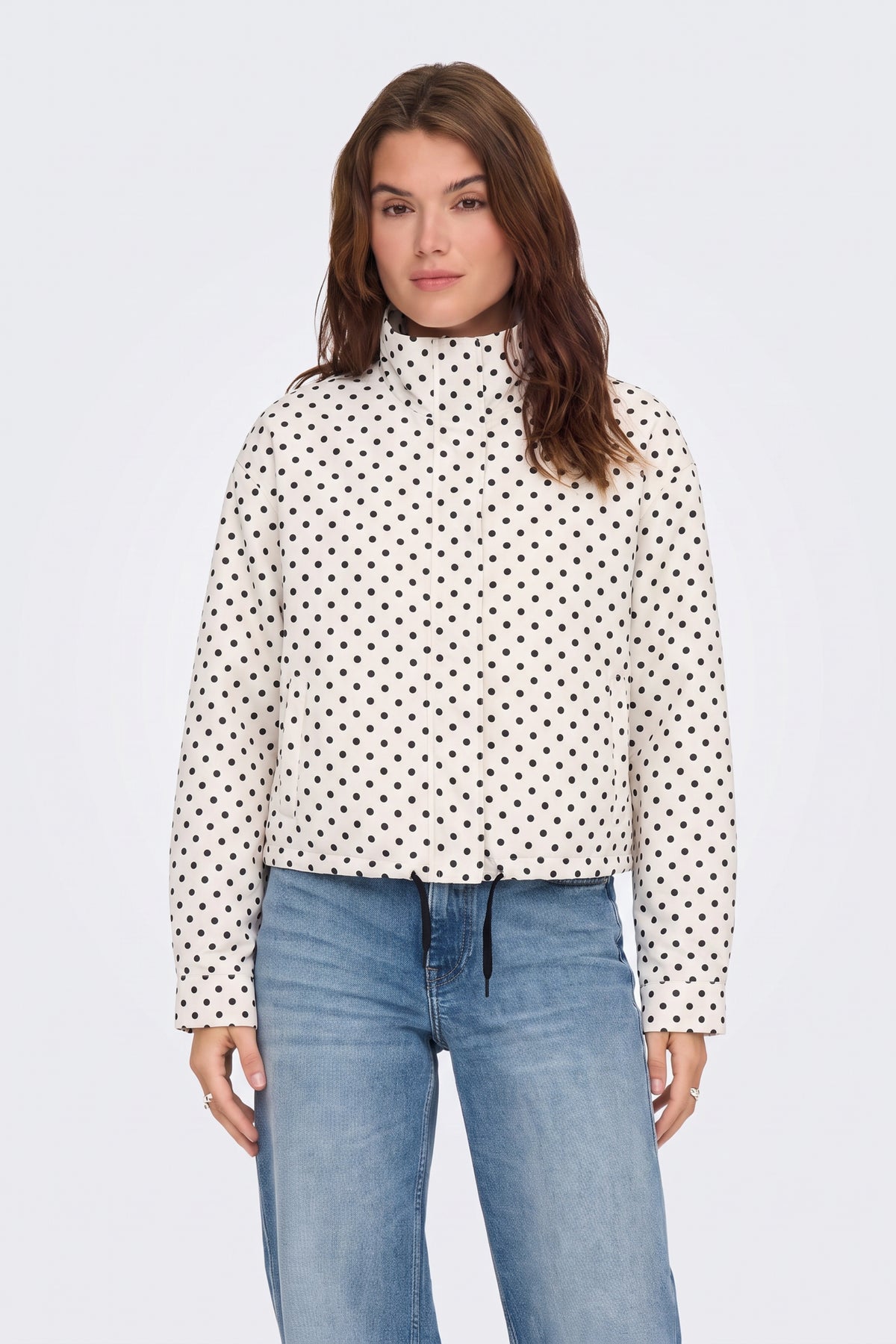 Cream polka dot jacket with blue jeans, on model