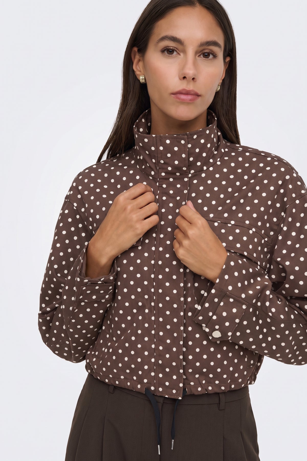 Brown polka dot puffer jacket funnel collar detail, on model