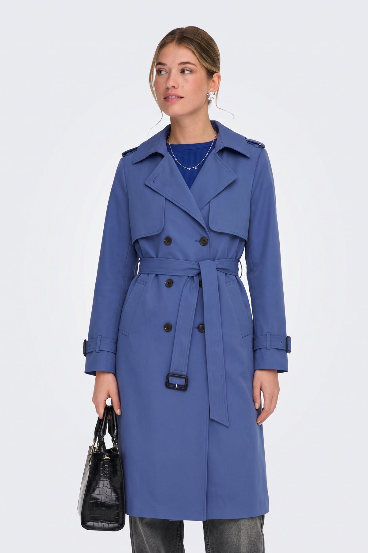 Blue long trench coat worn belted at the waist