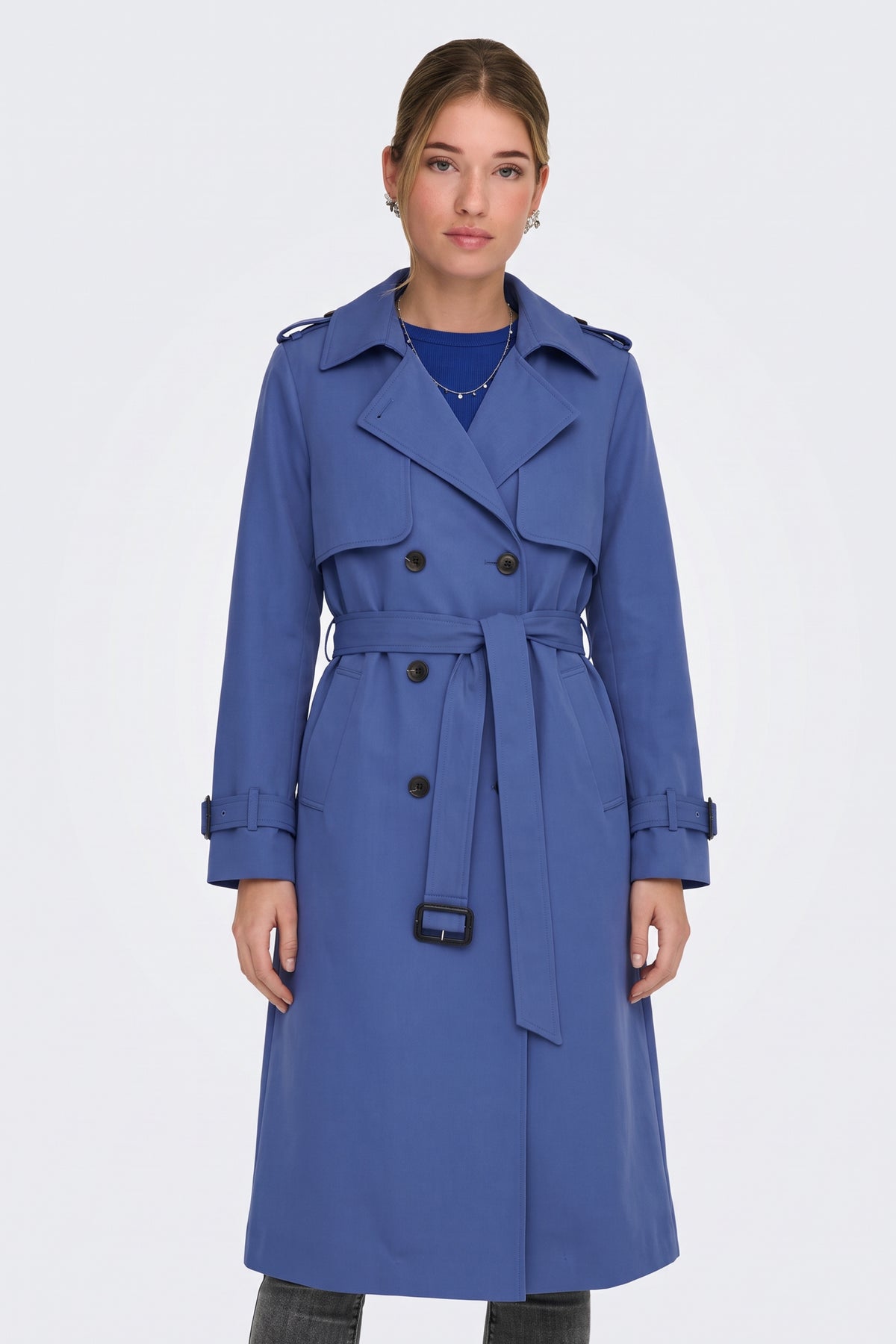 Blue belted trench coat on model, front view