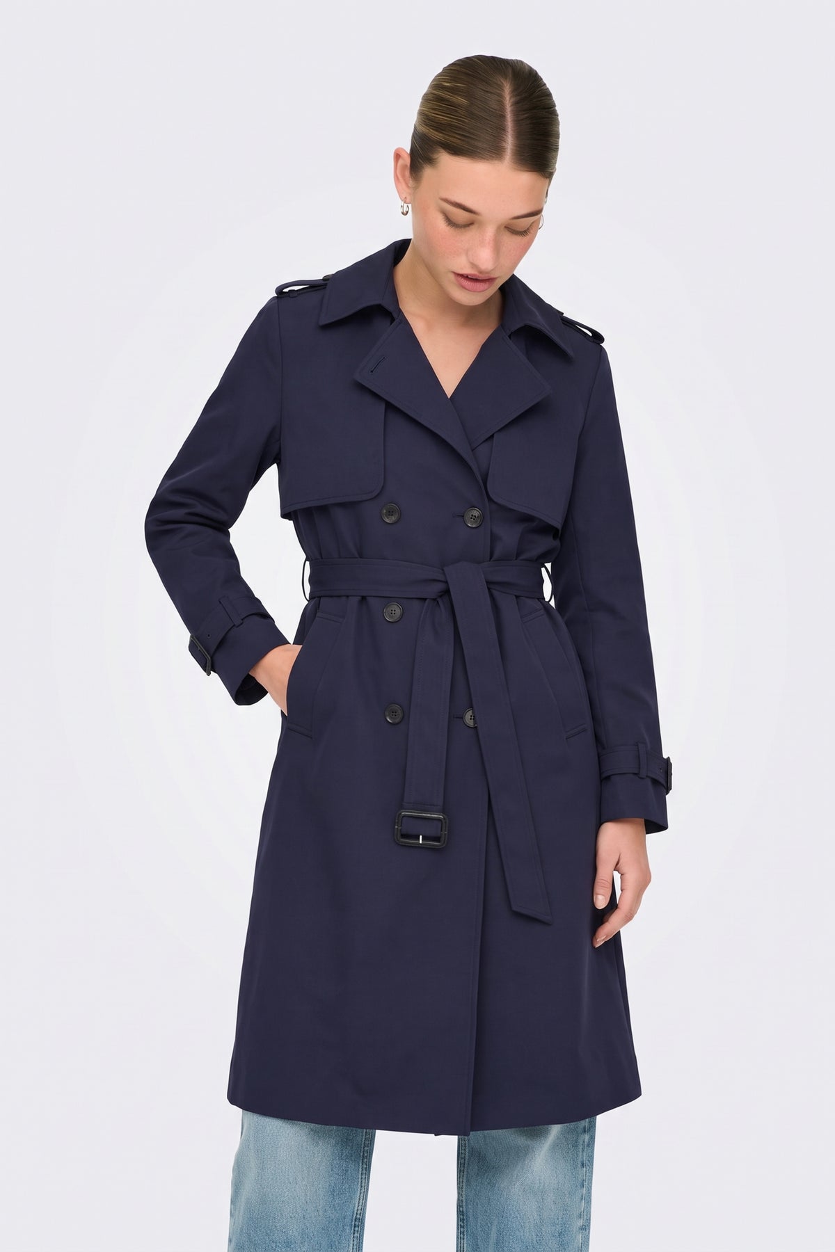 Navy belted trench coat on model, front view