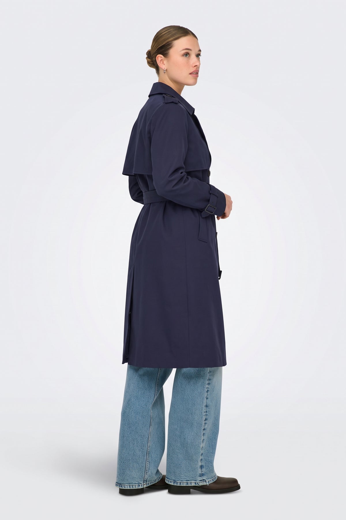 Navy long trench coat side view on model