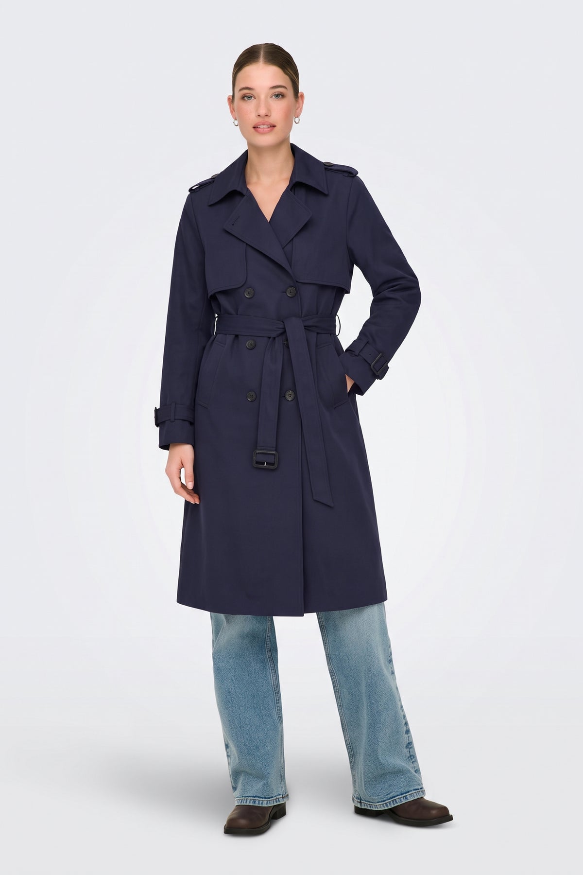 Navy long trench coat worn belted at the waist