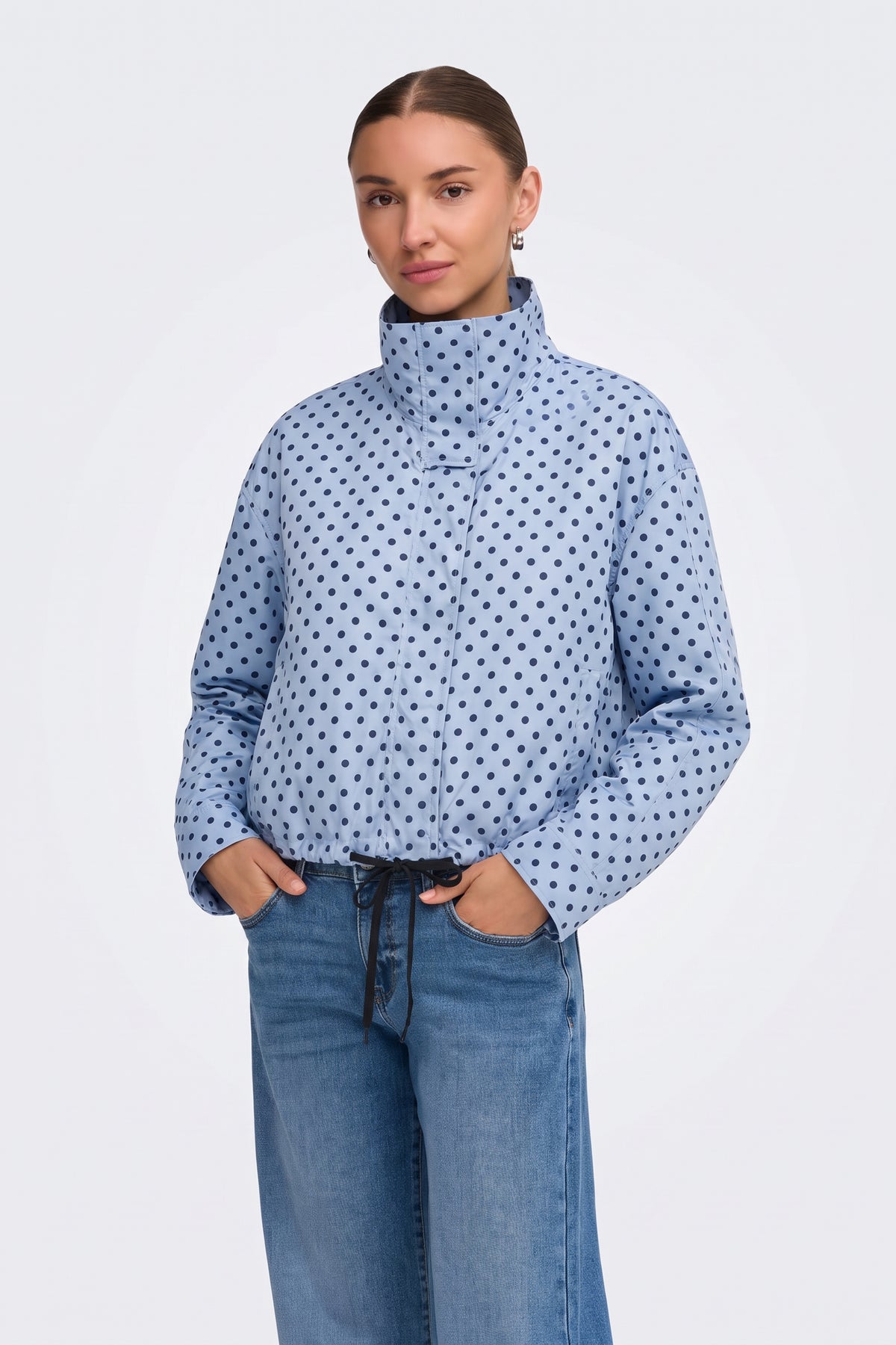 Light blue polka dot puffer jacket with blue jeans, on model