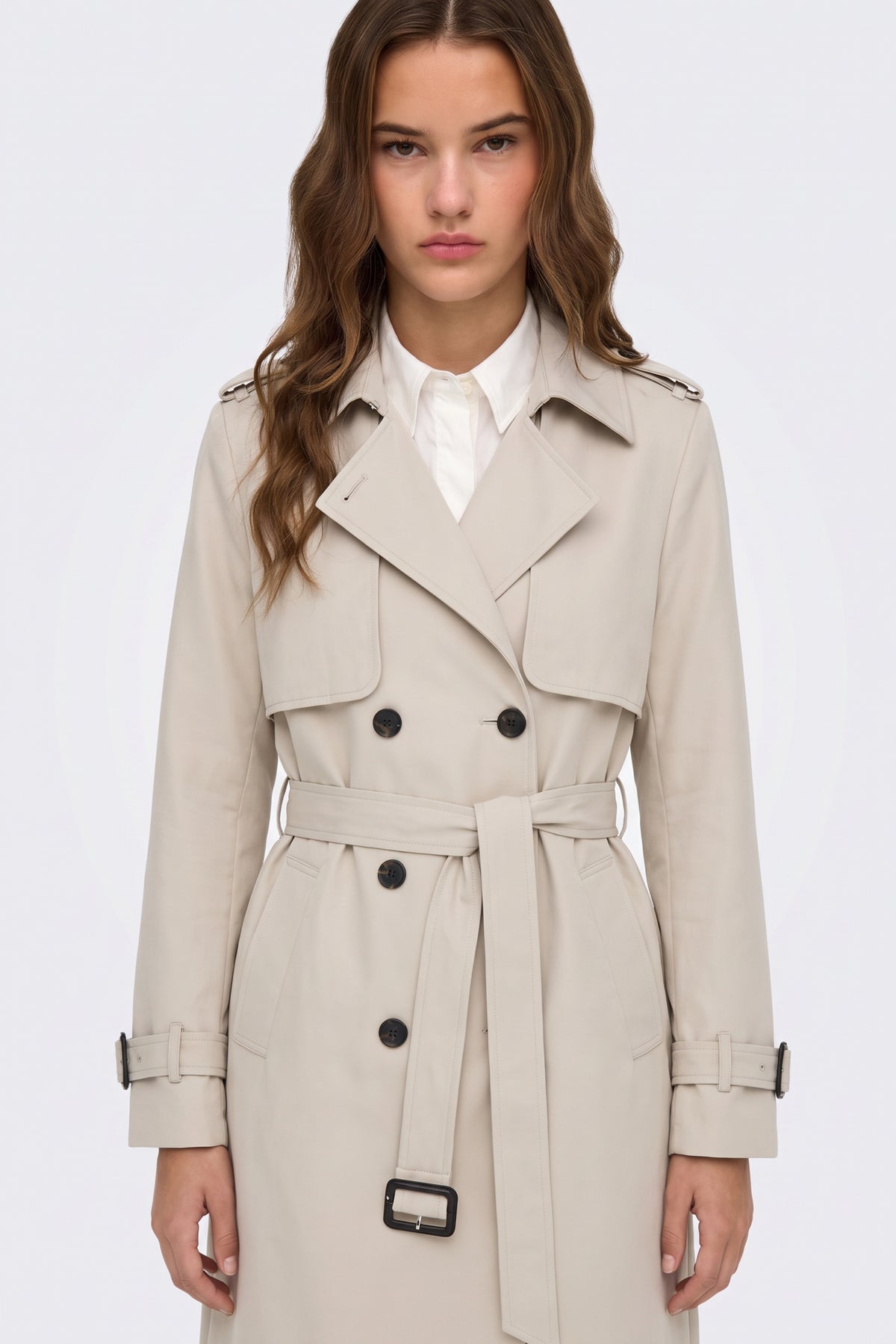 Cream trench coat with notch lapels and epaulettes on model