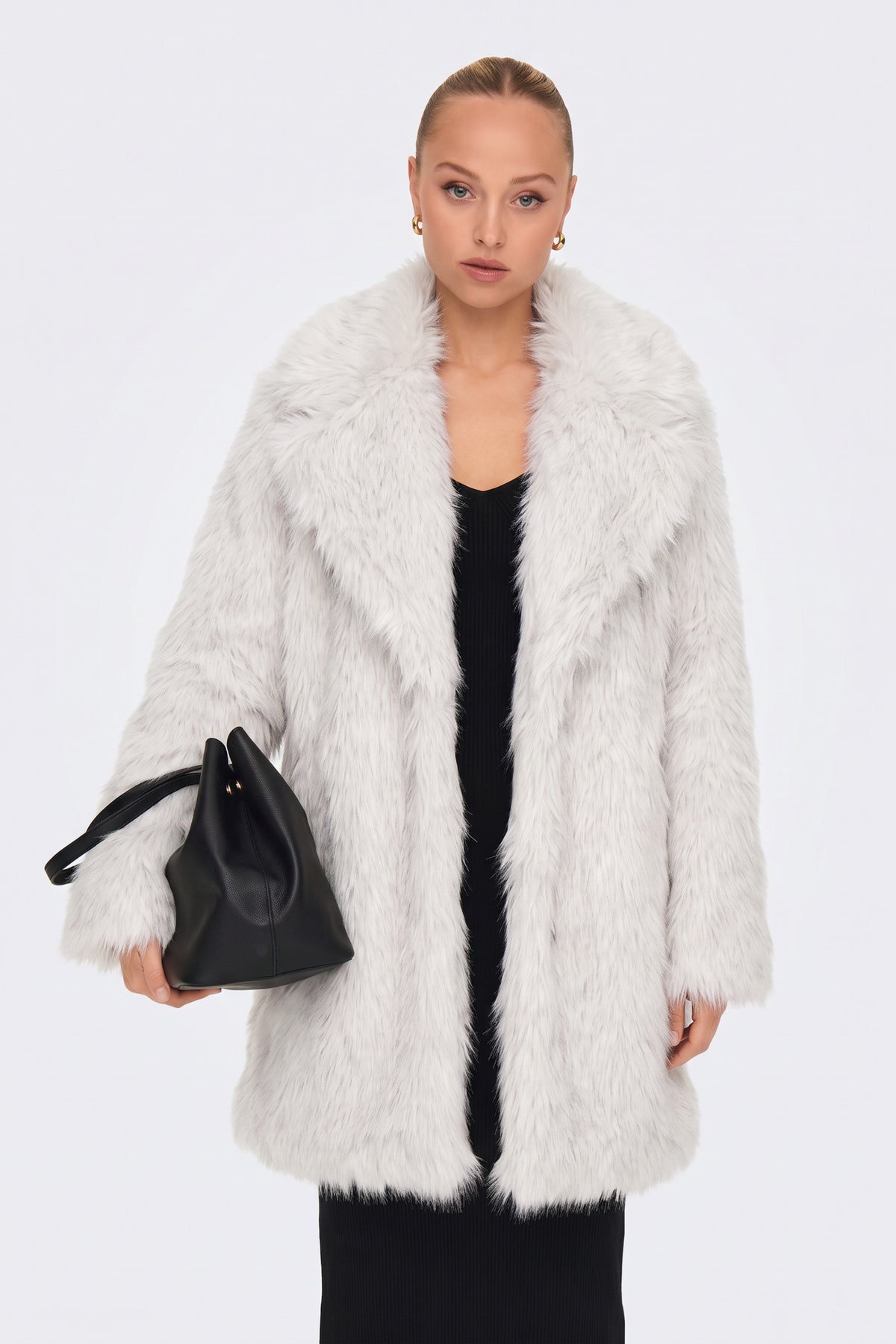 White faux fur coat worn open over a black outfit