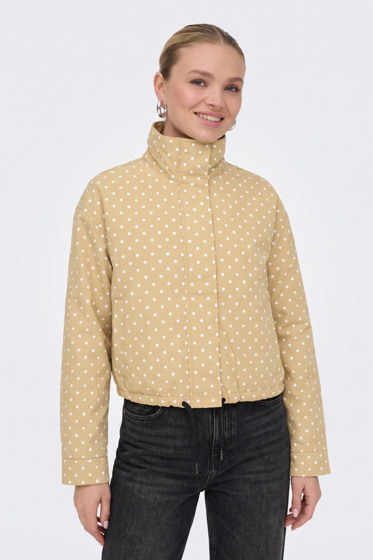 Yellow polka dot puffer jacket with funnel collar up, on model