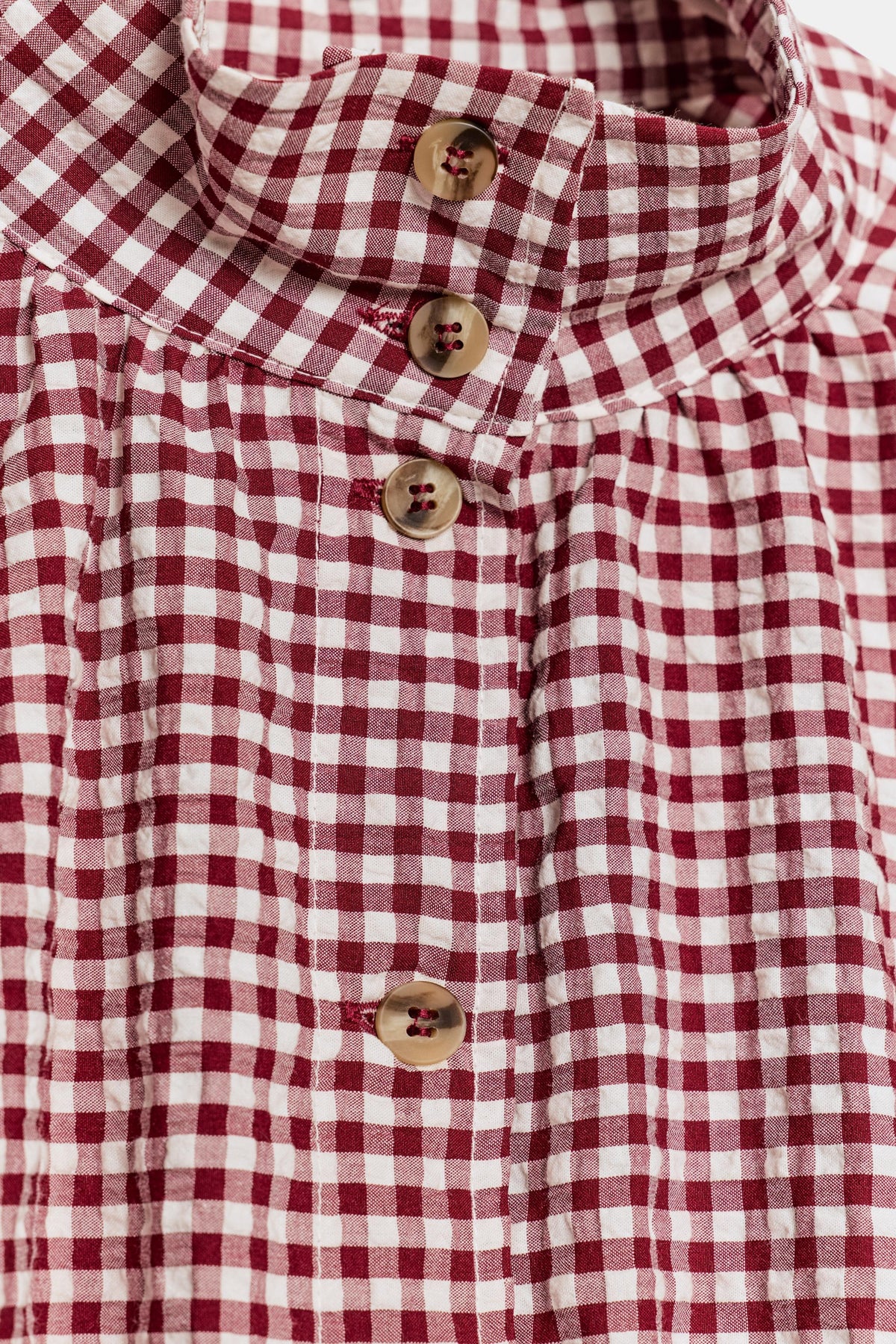 Burgundy gingham check fabric and tortoiseshell button detail