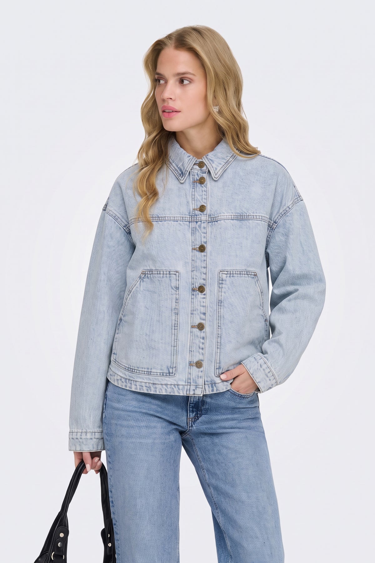 Light blue washed denim jacket with jeans, on model